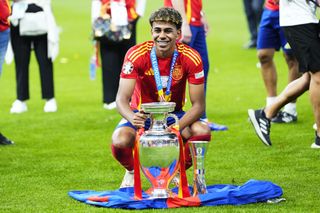 Lamine Yamal celebrates with the European Championship trophy after Spain's win at Euro 2024.